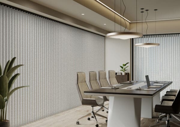 A boardroom with a large table with 4 chairs along one side in a neutral tones. Behind the desk is a large window with Durashade Rigid PVC louvres.