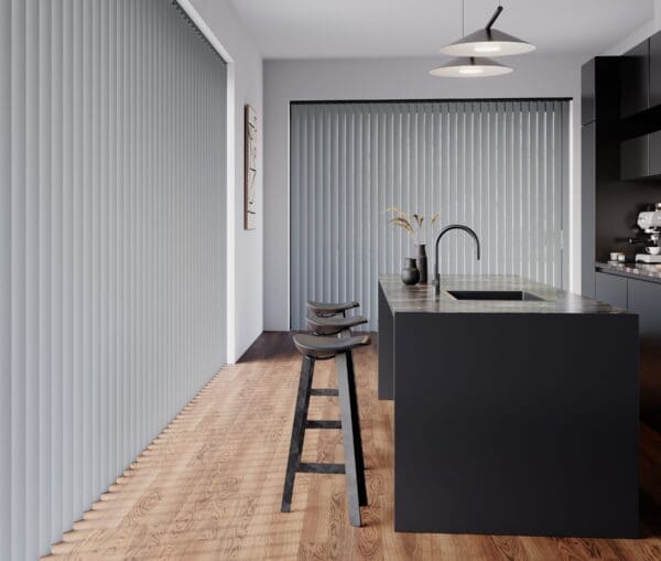 A kitchen island with seating in dark grey and black tones with a large window with Durashade Rigid PVC louvres in the background.